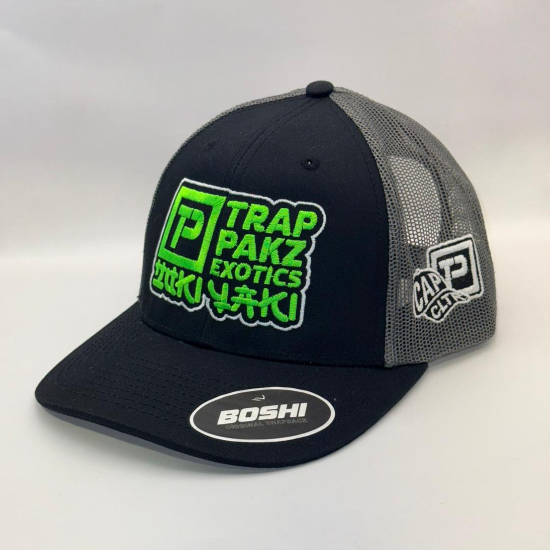 Black and gray cap with green and white text on a white background